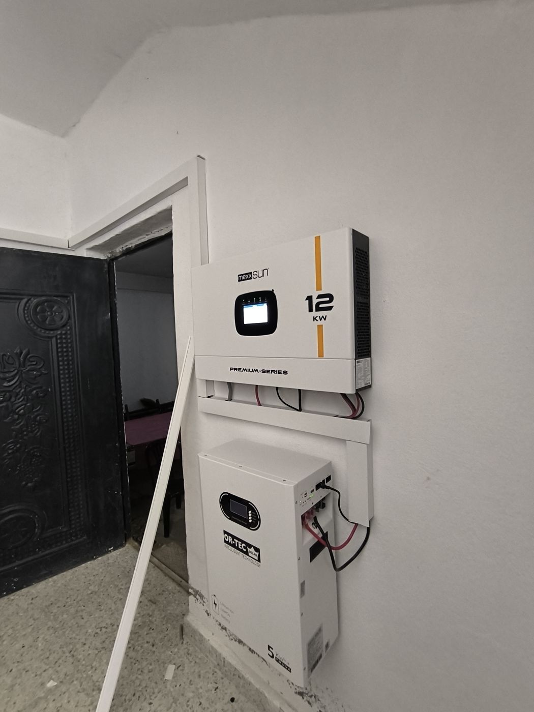 Duvara monte edilmiş 12 kW Mexxsun inverter ve altında OR-TEC lityum akü